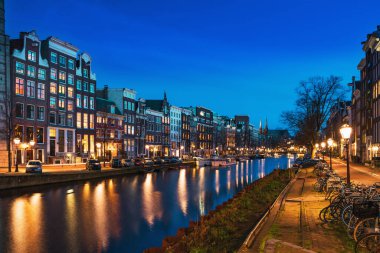 Hollanda, Hollanda 'da geceleri şehir ışıkları yansıyan tipik Hollanda dans evleriyle Amsterdam Kanalı