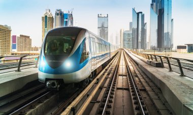 Dubai metro treni gökdelenlerin arka planında. Meşhur metro kırmızı hattı.