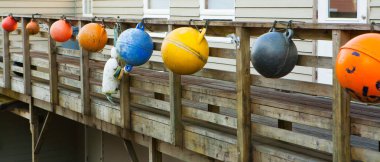 Colored fishing floats hung on pier clipart