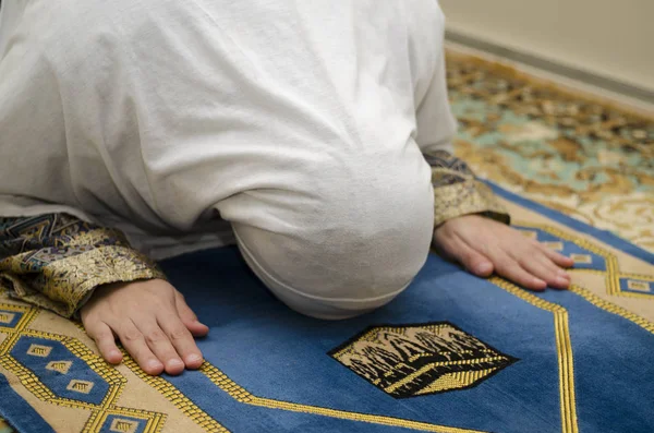 Donna che prega sul tappeto con l'immagine di Kaaba dal lato anteriore — Foto Stock