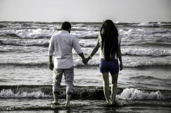 幸福牵手情侣在沙滩上波海或可爱的夫妇在海边。爱、 幸福、 浪漫的场景. — 图库照片