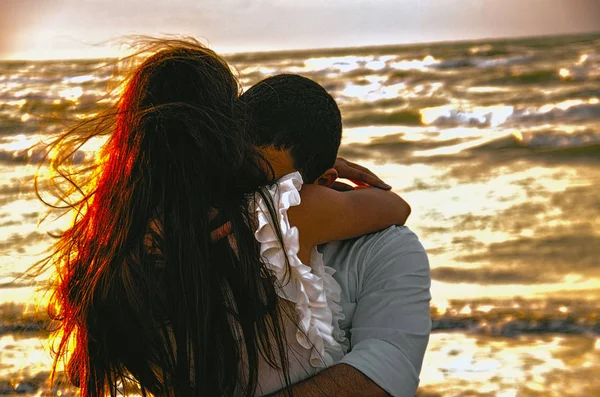 Feliz abrazo pareja en la playa con el mar borroso en el fondo o pareja encantadora en seaside.Love, felicidad, escena romántica . — Foto de Stock
