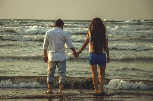 Happy holding hands couple on the beach with waves sea or lovely couple on seaside.Love,happiness,romantic scene. — Stock Photo, Image