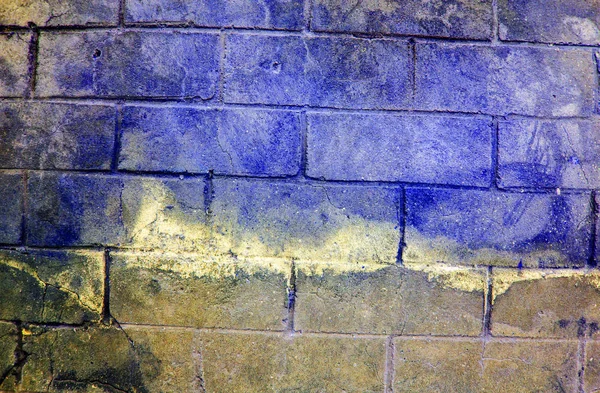 Fragment einer alten, schmutzigen Ziegelmauer mit abblätternder Putzstruktur weiß grau braun schwarz grün blau lindgelb orange kastanienbraun violett rosa türkis, Steinoberfläche mit Rissen, brauchbar als Hintergrundfarbe — Stockfoto