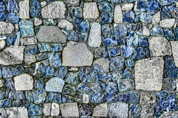 Fragment de vieux mur de briques avec des pierres de rivière texture blanc gris brun noir vert bleu citron vert jaune orange marron violet rose turquoise fond de couleur, différents types de pierres surface de la mosaïque — Photo