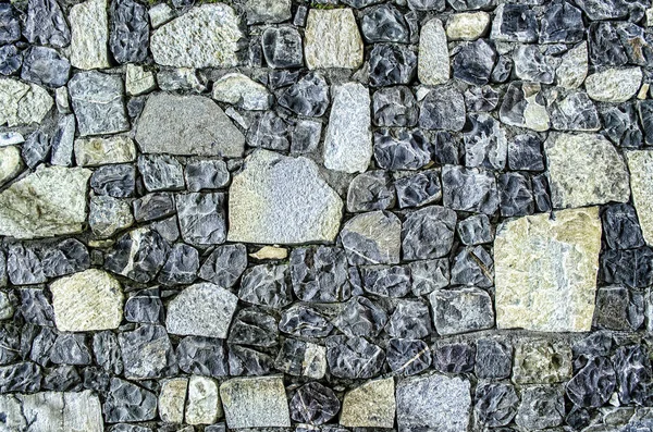 Fragment de vieux mur de briques avec des pierres de rivière texture blanc gris brun noir vert bleu citron vert jaune orange marron violet rose turquoise fond de couleur, différents types de pierres surface de la mosaïque — Photo