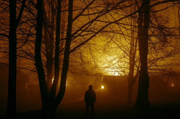 Étrange silhouette dans une sombre forêt effrayante la nuit, paysage mystique lumières surréalistes avec homme effrayant, feu brûlant — Photo