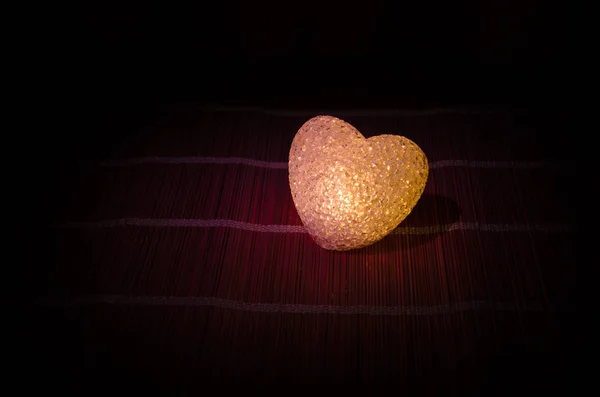 Composition de la Saint-Valentin avec coeur multicolore brûlant doux sur fond sombre, foyer sélectif ou carte de souhaits d'amour de coeur rouge vert rose jaune — Photo