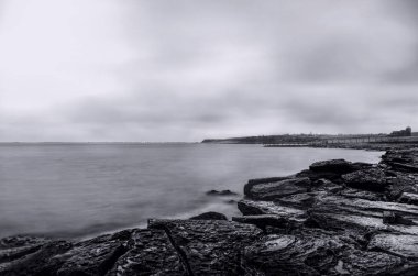 sahil sahne, deniz manzarası, bulutlu gökyüzü. Güzel deniz manzarası. Deniz ve güneşin kış zamanında kayaya. Hazar Denizi, Abşeron, Azerbaycan gri tonlama