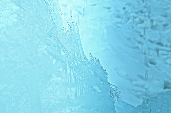 outdoor view of ice blocks at frozen water in winter texture with light white snow covering chunks of cracked ice on a frozen winter ground