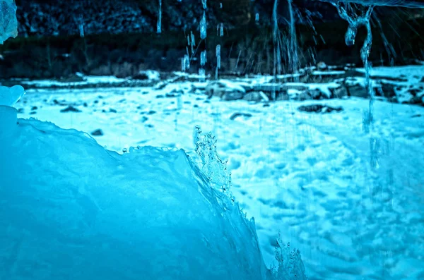 Vista esterna di blocchi di ghiaccio in acqua ghiacciata in struttura invernale con neve bianca leggera che copre pezzi di ghiaccio incrinato su un terreno invernale ghiacciato — Foto Stock