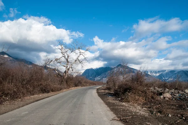 Paisaje de camino de asfalto que va hacia los pasos de montaña a través de los árboles, pueblos y lugares forestales. o lugares rurales de Azerbaiyán al atardecer —  Fotos de Stock
