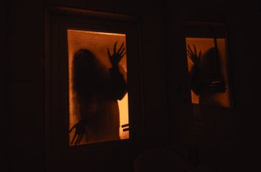 Horror woman in window wood hand hold cage scary scene halloween concept Blurred silhouette of witch clipart