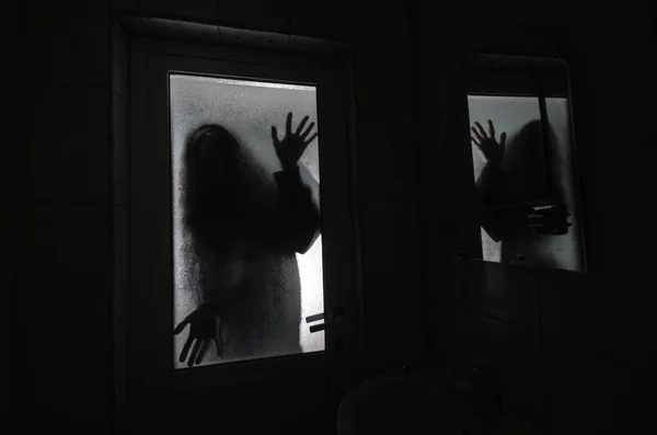 Horror mujer en ventana madera mano celebrar jaula miedo escena halloween concepto silueta borrosa de bruja — Foto de Stock