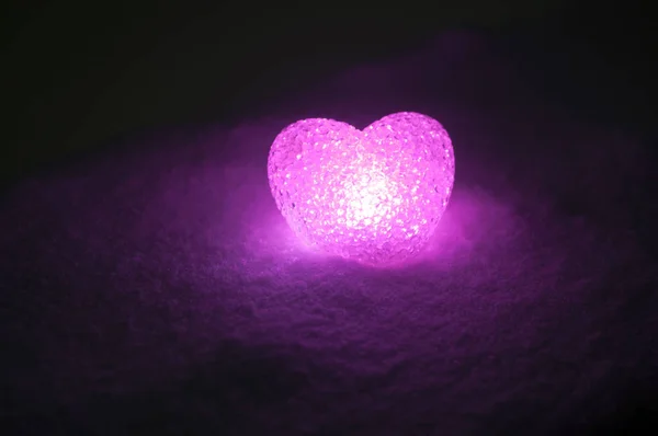 Coeur de verre abstrait sur la neige la nuit. Carte pour une Saint-Valentin. lumière rose coeur sur fond noir — Photo