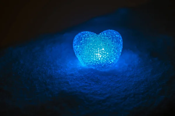 Coeur de verre abstrait sur la neige la nuit. Carte pour une Saint-Valentin. lumière de coeur bleu sur fond noir — Photo