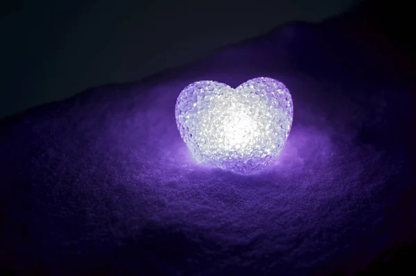 Coração de vidro abstrato na neve à noite. Cartão para o dia dos namorados. luz do coração violeta no fundo preto — Fotografia de Stock