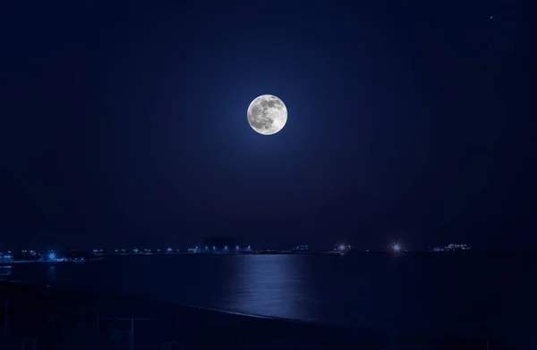 Foto van volle maan in zwarte hemel boven de zee met reflectie — Stockfoto