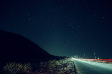 Yıldız, gökyüzü ve dağ siluet road araba yollar ile yakınındaki güzel gece manzarası. Yol bir yıldızlı gyres altında dağlarda. Azerbaycan, büyük Kafkasya, Şəki