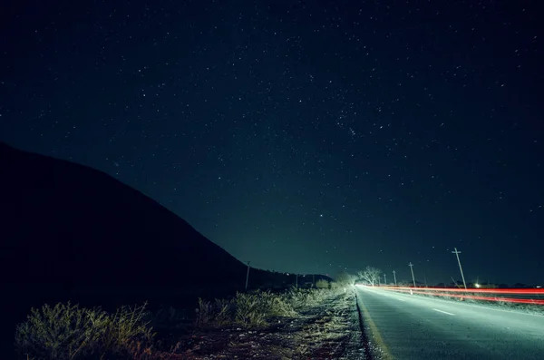 空と山のシルエット車歩道と道路の近くで星の美しい夜の風景。星空の環流の下で山の道。アゼルバイジャン、大コーカサス山脈、シェキ — ストック写真