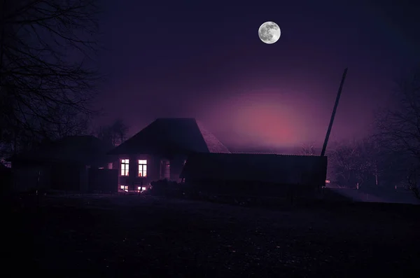 Дом в тумане ночью в саду, пейзаж дома-призрака в темном лесу с большой полнолуние — стоковое фото