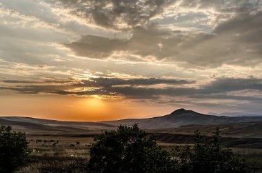 Güzel bir akşam görünümü Azerbaycan dağlar yeşil otlar çayırlar ve hills adlı günbatımı zamanı. Yaz Zamanı