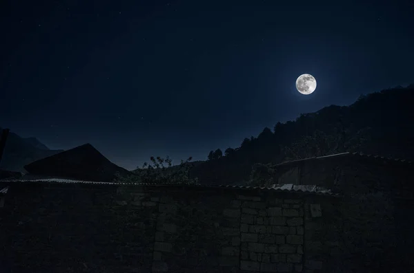 Hermoso paisaje de la aldea de montaña de Ilisu en la ladera. Grandes montañas del Cáucaso en la noche a plena luz de la luna. Azerbaiyán naturaleza — Foto de Stock