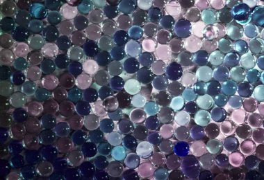 Mermer kristal berraklığında topu, gökkuşağı renkli parlak arka plan parıldıyor. Seçici odak. Çok renkli