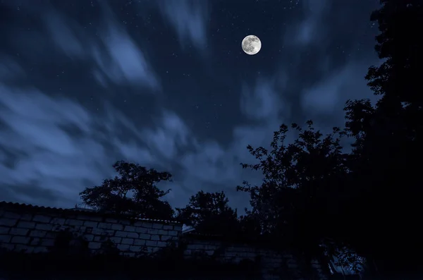 Hermosa calle del pueblo paisaje con edificios y árboles y gran luna llena en el cielo nocturno. Gran Cáucaso. Naturaleza de Azerbaiyán Gazakh — Foto de Stock