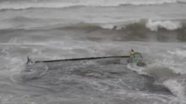 Deniz dalgaları kazasında kaya karşı Hazar denizin dalgaları bulutlu hava sahilde kayalık ve eski metalik inşaatı çökmesini. Azerbaycan Abşeron Novkhani