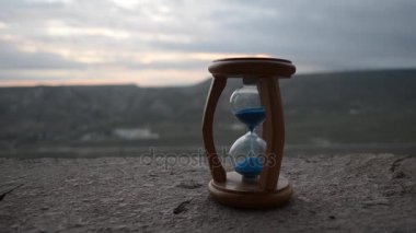 Zaman kavramı. Kum saati saat ve bulanık doğa arka plan günbatımı zaman duman silüeti veya simgeler zaman duman, zaman biter veya aşk biter. İyimser veya kötümser fikirler.