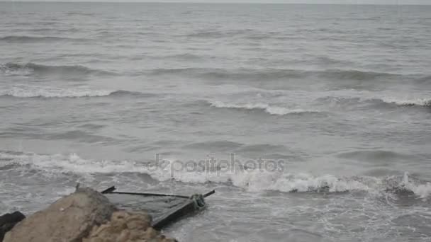 Ondas do mar bater contra a rocha, As ondas do Mar Cáspio estão batendo em uma construção metálica rochosa e velha na praia Clima nublado. Azerbaijão Absheron Novkhani — Vídeo de Stock