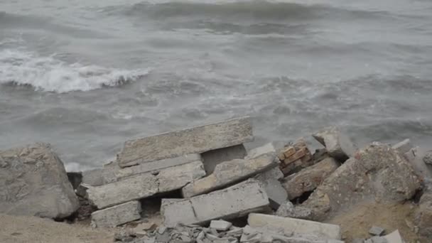 岩に海の波のクラッシュ、カスピ海の波は曇りの天候のビーチで岩場や古い金属構造にクラッシュします。アゼルバイジャン アプシェロン Novkhani — ストック動画