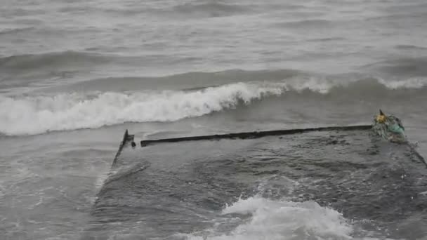 Olas del mar chocan contra la roca, las olas del mar Caspio se están estrellando en una construcción rocosa y metálica de edad en la playa tiempo nublado. Azerbaiyán Absheron Novkhani — Vídeo de stock