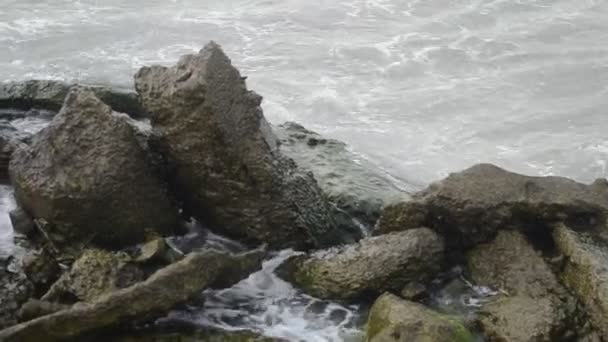 Onde del mare si schiantano contro la roccia, Le onde del Mar Caspio si stanno schiantando su una costruzione rocciosa e vecchia metallica sulla spiaggia Tempo nuvoloso. Azerbaigian Absheron Novkhani — Video Stock