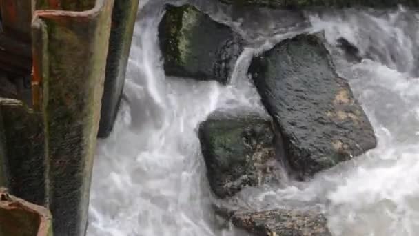 Olas del mar chocan contra la roca, las olas del mar Caspio se están estrellando en una construcción rocosa y metálica de edad en la playa tiempo nublado. Azerbaiyán Absheron Novkhani — Vídeo de stock