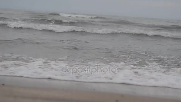 Las olas del mar Caspio se enrollan en una playa de arena y concha con una piedra de granito amarillo. Clima nublado enfoque selectivo. Absheron Azerbaiyán — Vídeo de stock