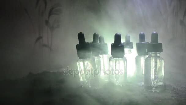 Concetto di vaporizzatore. Nuvole di fumo e bottiglie liquide vaporizzate su sfondo scuro. Effetti luce. Utile come sfondo o vaporizzare pubblicità . — Video Stock