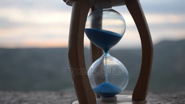 Concepto de tiempo. Silueta de reloj de arena y humo en el fondo borroso de la naturaleza al atardecer, o símbolos del tiempo bajo el humo, el tiempo termina o el amor termina. Ideas optimistas o pesimistas . — Vídeos de Stock