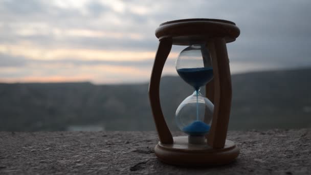 Concetto temporale. Silhouette di orologio a clessidra e fumo su sfondo natura sfocata al tramonto, o simboli del tempo sotto fumo, il tempo finisce o l'amore finisce. Idee ottimistiche o pessimistiche . — Video Stock