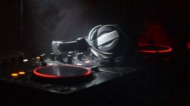DJ iplik, karıştırma ve tırmalamak dj elinde bir gece kulübünde dj's güverte, strobe ışıklar ve sis, seçici odak çeşitli parça denetimlere tweak, yakın çekim. DJ müzik kulübü hayat kavramı