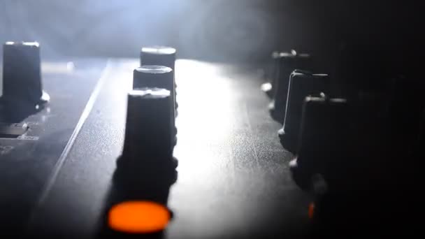 DJ Spinning, Mixing, and Scratching in a Night Club, Manos de dj ajustar varios controles de pista en la cubierta de dj, luces estroboscópicas y niebla, enfoque selectivo, de cerca. Dj Concepto de vida del club de música — Vídeo de stock
