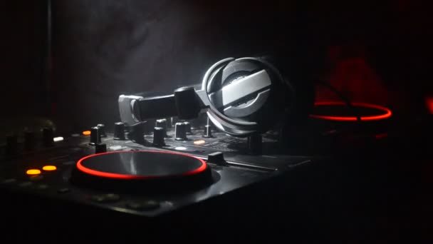 DJ Spinning, Mixing, and Scratching in a Night Club, Hands of dj tweak vari controlli delle tracce sul ponte del DJ, luci stroboscopiche e nebbia, messa a fuoco selettiva, da vicino. Concetto di vita del Dj Music club — Video Stock