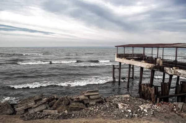 Bela paisagem surreal de casa abandonada e escada na costa rochosa ao pôr-do-sol. Tempo nublado. Mar Cáspio, Azerbaijão , — Fotografia de Stock