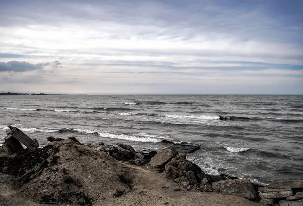 Sonnenuntergang am Ufer eines Strandes mit Felsen und stürmischen Wellen, wunderschöne Meereslandschaft am Kaspischen Meer, Azerbaijan novkhani — Stockfoto