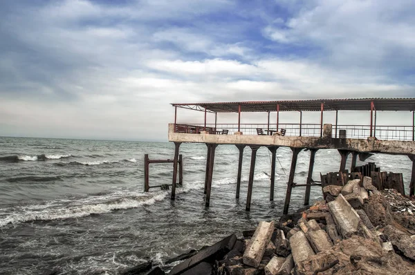 Bela paisagem surreal de casa abandonada e escada na costa rochosa ao pôr-do-sol. Tempo nublado. Mar Cáspio, Azerbaijão , — Fotografia de Stock