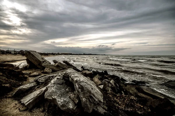 Sonnenuntergang am Ufer eines Strandes mit Felsen und stürmischen Wellen, wunderschöne Meereslandschaft am Kaspischen Meer, Azerbaijan novkhani — Stockfoto