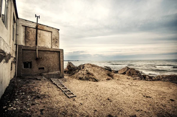 Hermoso paisaje surrealista de casa abandonada y escalera en la costa rocosa al atardecer. Clima nublado. Mar Caspio, Azerbaiyán , —  Fotos de Stock