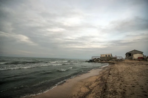 Hermoso paisaje surrealista de casa abandonada y escalera en la costa rocosa al atardecer. Clima nublado. Mar Caspio, Azerbaiyán , —  Fotos de Stock