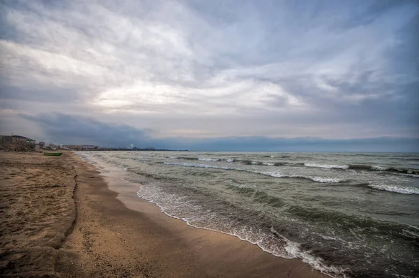 Apus de soare pe malul mării al unei plaje cu pietre și valuri furtunoase, capac de mare frumos la Marea Caspică Absheron, Azerbaidjan Novkhani — Fotografie, imagine de stoc